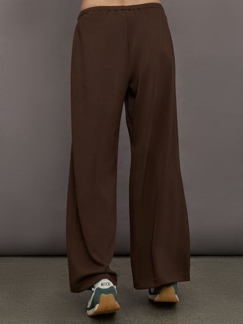 Model is wearing Scuba Mid Rise Pull On Pant in Carafe, back view.