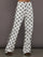 Model is wearing the Polka Dot Track Pant in white with carafe polka dot print shown from the front with wide leg silhouette and contrast side stripe.