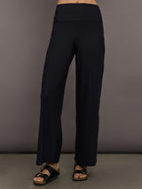 Model is wearing Pleated Palazzo Pant in Melt Black, front view.
