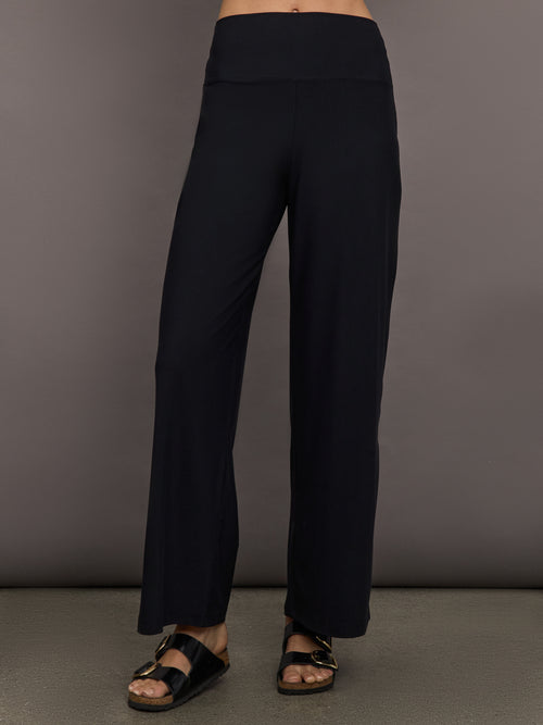 Model is wearing Pleated Palazzo Pant in Melt Black, front view.