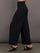 Model is wearing Pleated Palazzo Pant in Melt Black, side profile view.