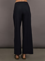 Model is wearing Pleated Palazzo Pant in Melt Black, back view.