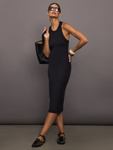 Woman wearing a black ribbed sleeveless dress against a gray background
