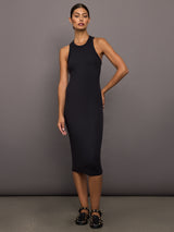 Woman wearing a black ribbed sleeveless dress against a gray background