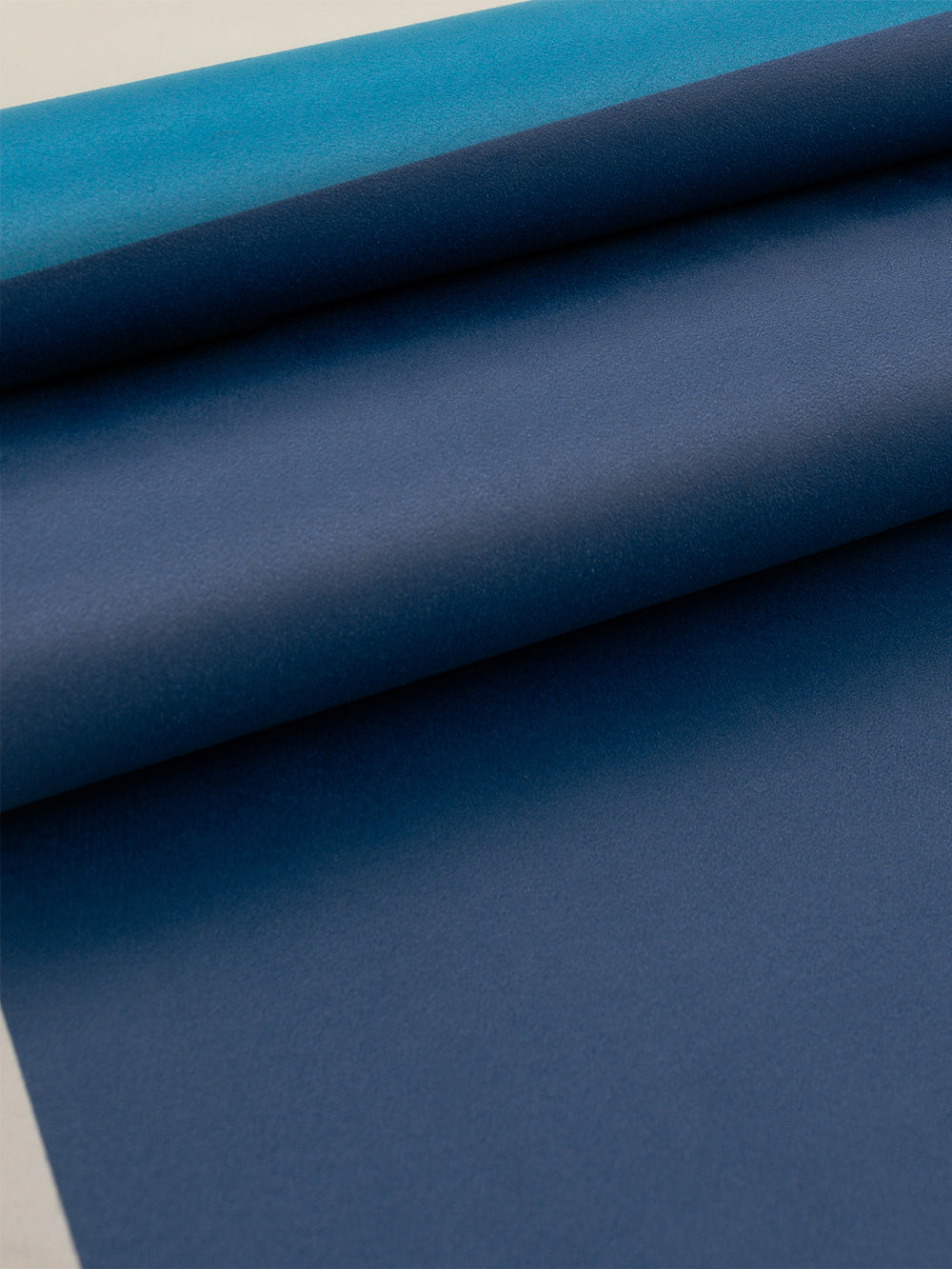 Close-up of Navy Aeris yoga mat in Navy and Blue showing smooth textured grip and layered color detail.