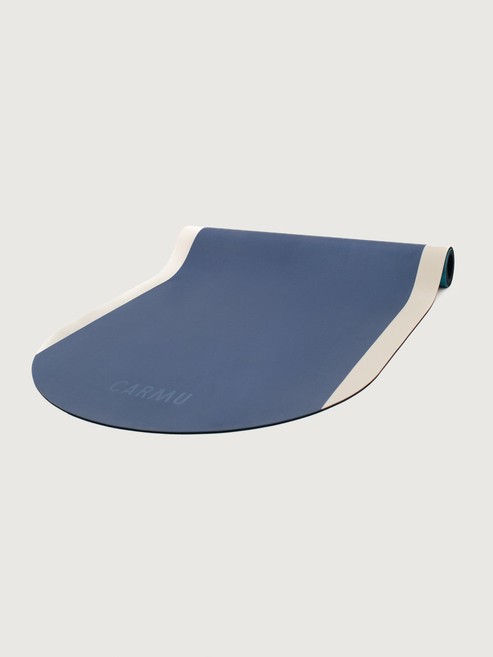 Angled view of Navy Aeris yoga mat in Navy and Blue partially unrolled with CARMU branding.
