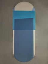 Navy Aeris yoga mat in Navy and Blue geometric design displayed flat on textured concrete surface with CARMU logo.