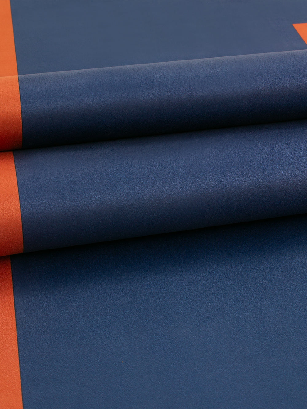 Close-up of Echo yoga mat in Navy and Dark Red showing smooth textured grip and colorblock detail.