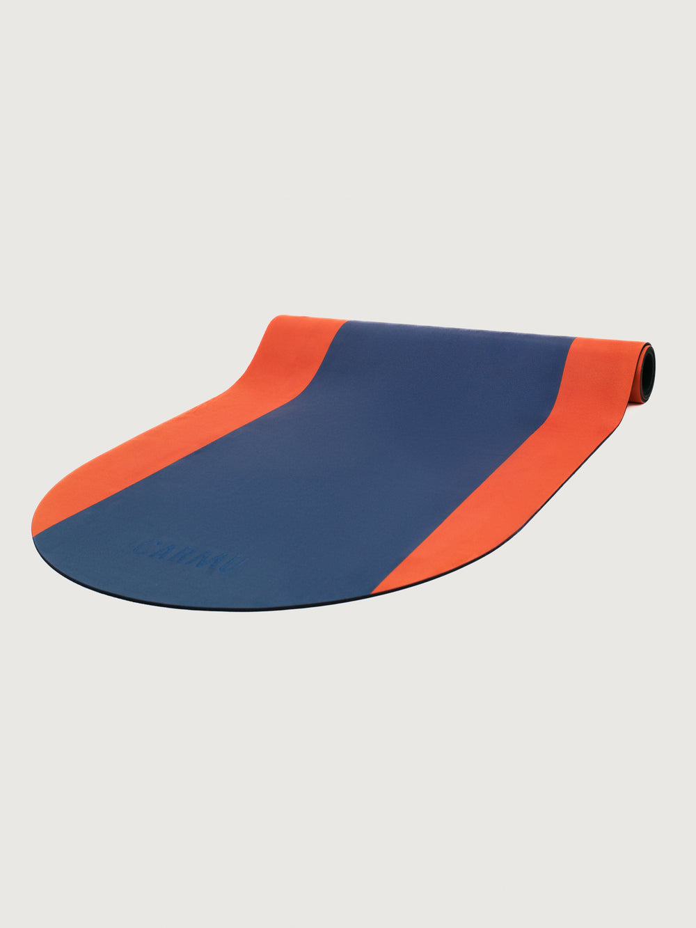 Angled view of Echo yoga mat in Navy and Dark Red colorblock design partially unrolled with CARMU branding.