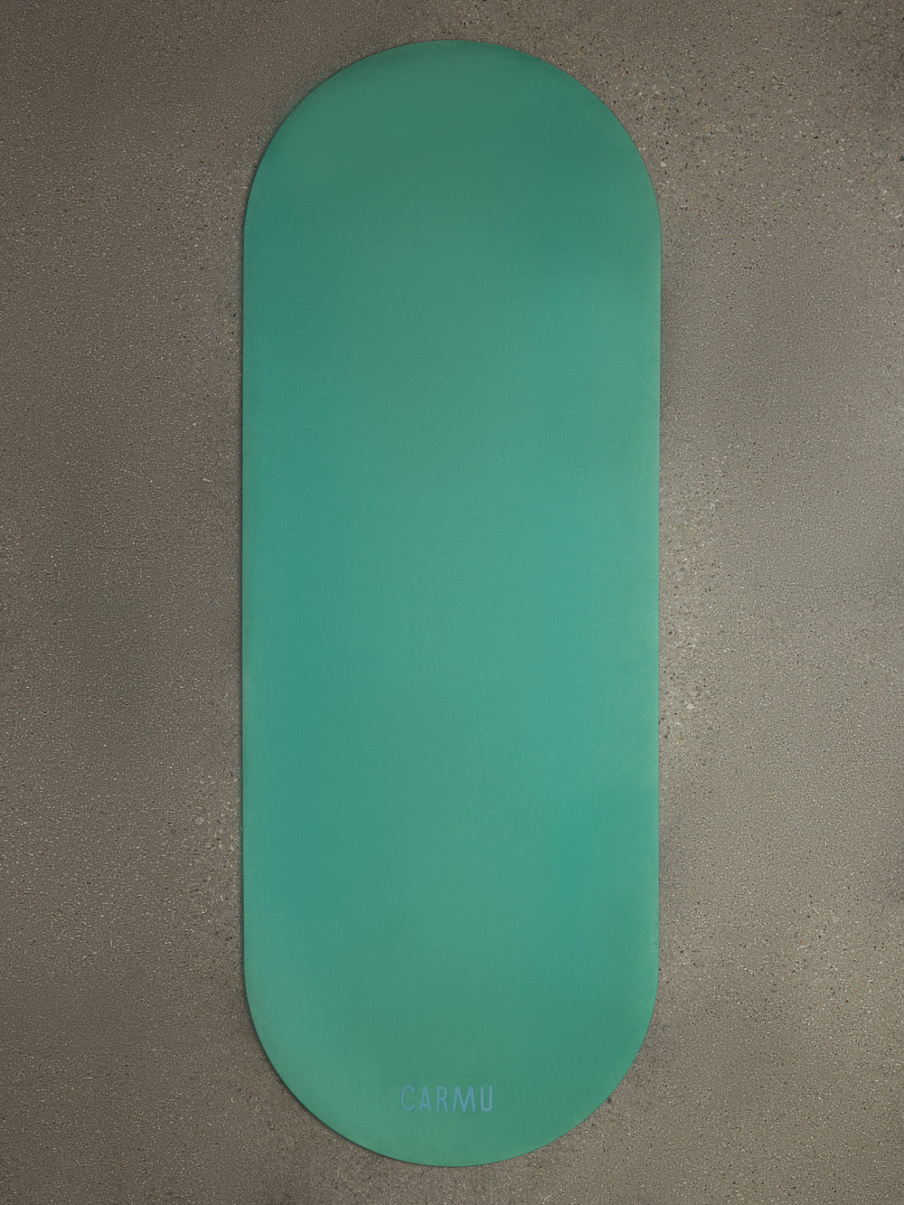 Teal Gradient yoga mat displayed flat on textured concrete surface with CARMU logo visible.