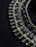 Close-up of black jewel embellished sweatshirt showing crystal beading and textured detail.
