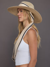 Side profile of model in natural hemp fedora with ivory scarf and contrast trim.