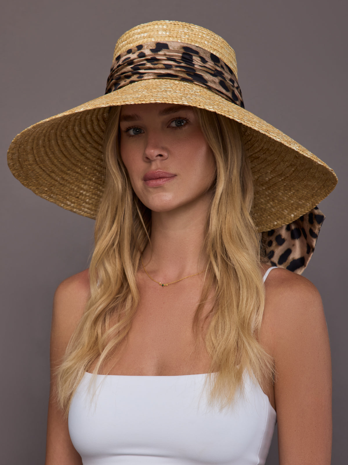 Model is wearing the wide brim straw sun hat in natural, front view.