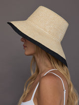 Side profile of ivory and black two-tone wide-brim straw sun hat.