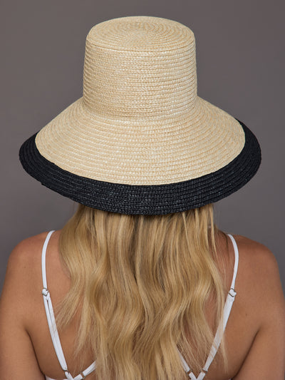 Back view of ivory straw sun hat with wide black brim.