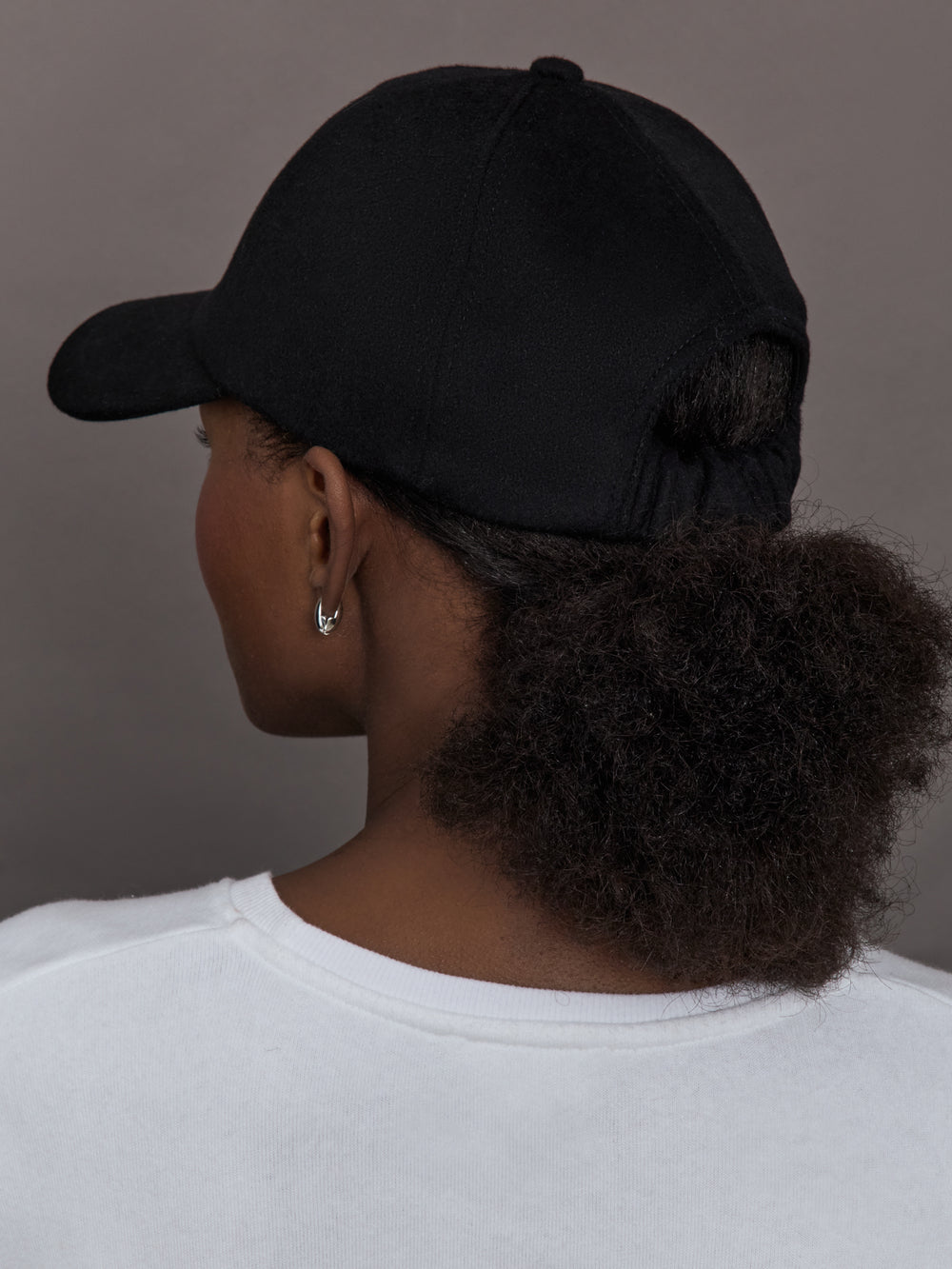 Model wearing black baseball cap