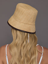 Back view of natural woven straw bucket hat showing contrast trim edge.