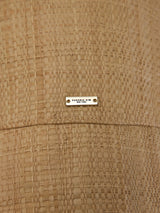 Close-up of woven straw bucket hat with logo plaque detail.