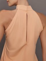 Model is wearing a peach mock neck halter top and skirt against a plain background.