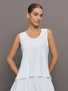 Model wears a loosely fitted round neck white tank top. 