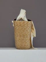 Side view of oversized straw tote in natural straw with ivory satin bow detail.