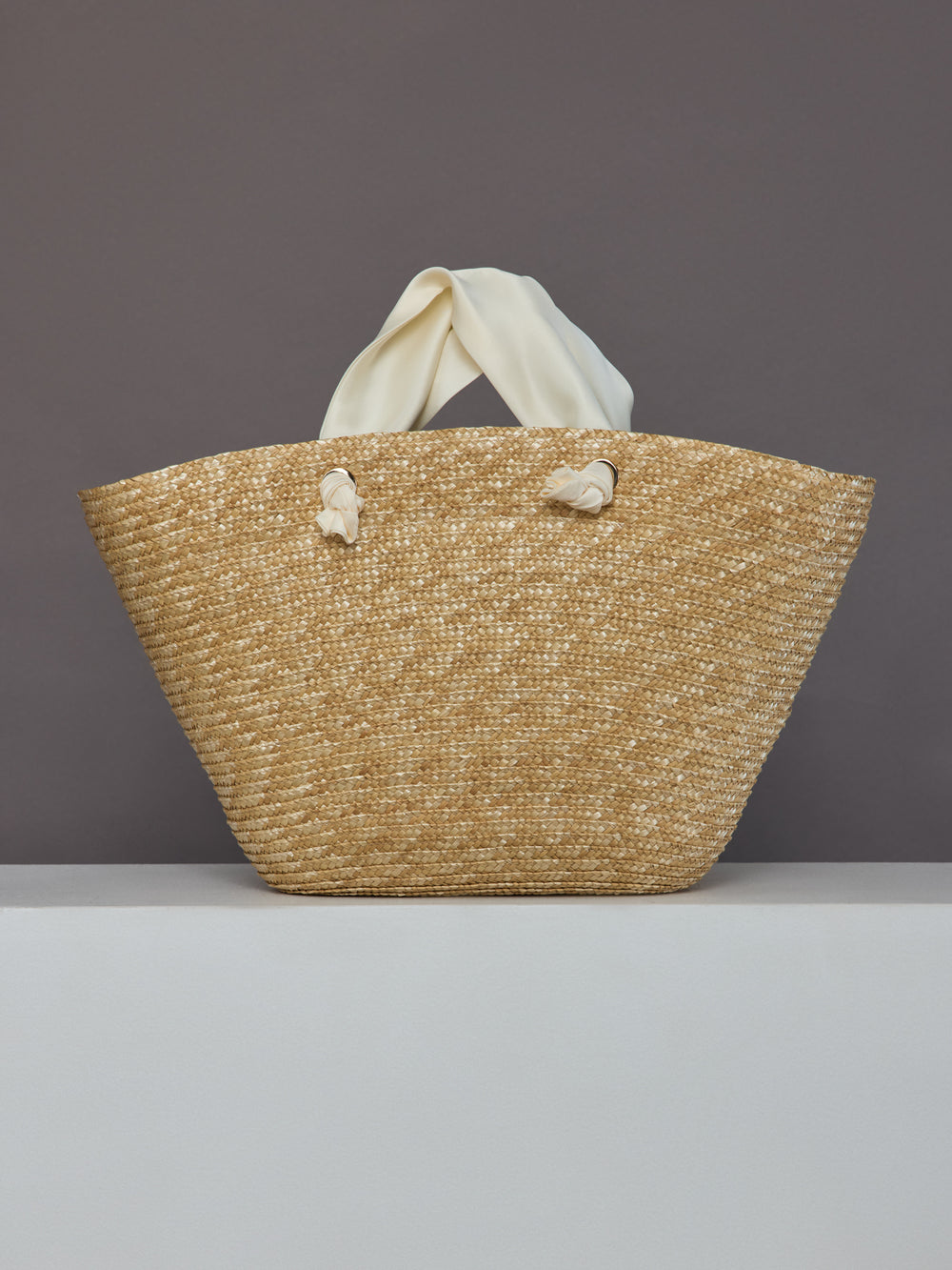 Back view of straw tote bag with ivory satin handles and no bow.