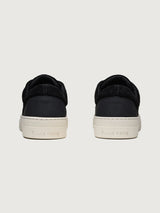Filling Pieces Riviera Fuzz sneakers in black with suede heel panel, perforated FP logo, and white rubber sole, back view.
