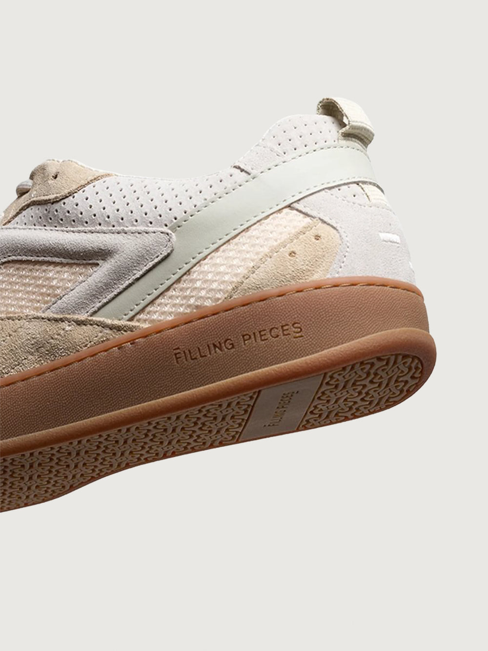 Close-up of Filling Pieces Prism Peak sneaker in beige with perforated leather heel, embossed logo on gum sole, and textured outsole.