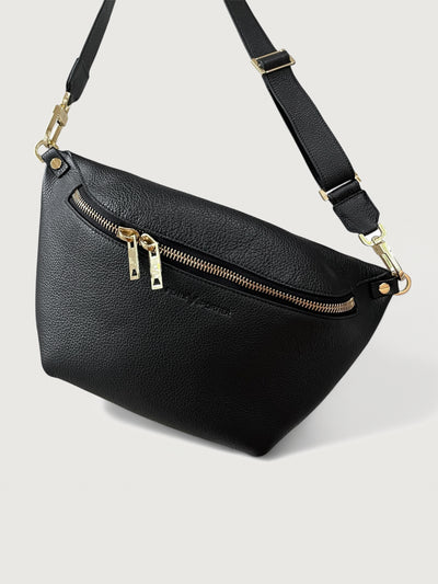 Black pebbled leather handbag that can also be worn as a crossbody with gold hardware and double zippers. 