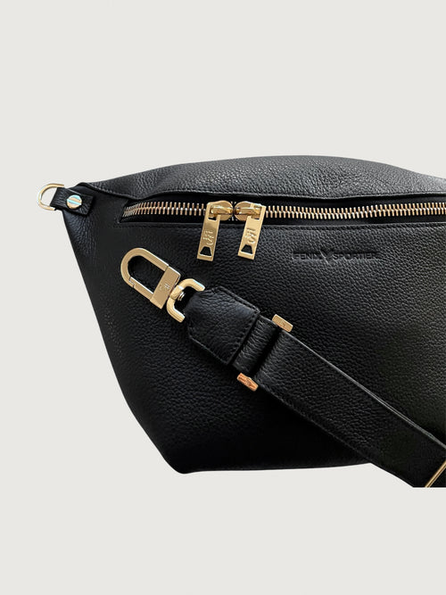 Black pebbled leather handbag that can also be worn as a crossbody with gold hardware and double zippers. 