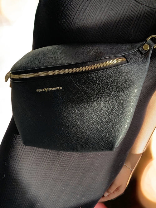 Black pebbled leather handbag that can also be worn as a crossbody with gold hardware and double zippers. 