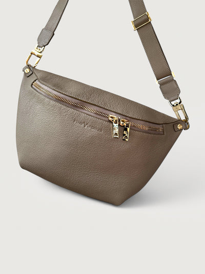 Beige/taupe pebbled leather handbag that can also be worn as a crossbody with gold hardware and double zippers. 