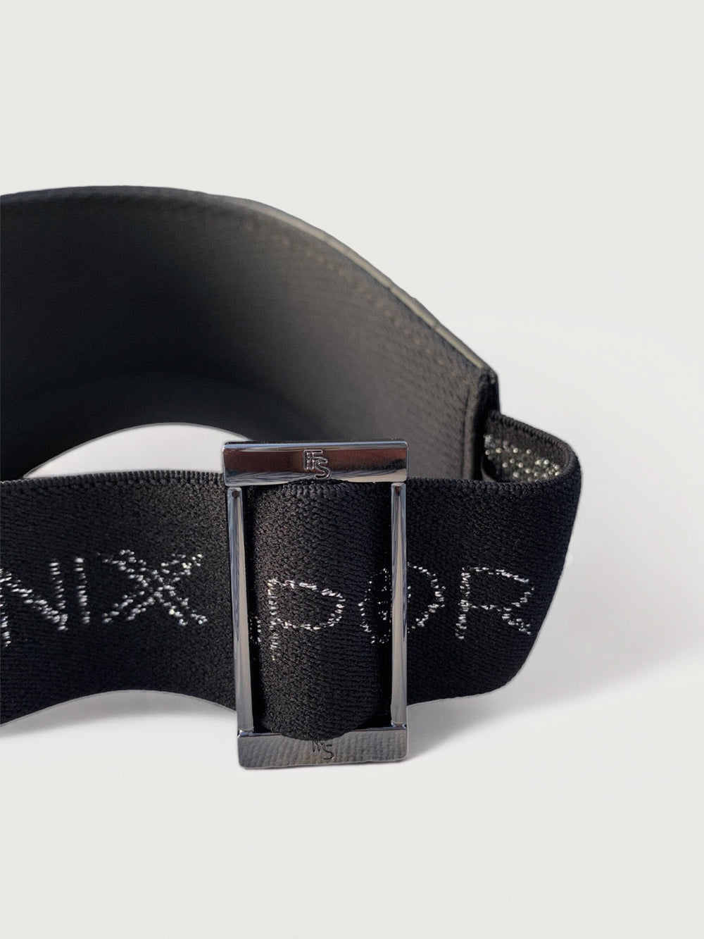 A black mesh textured shiny visor with a thick black strap that says Fenix Sportier. 