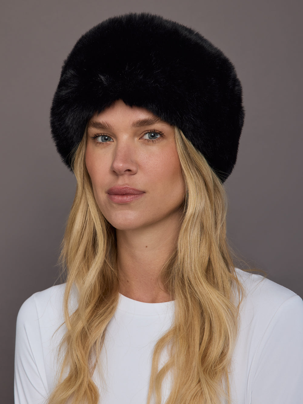 Black faux fur headband on model, front view.