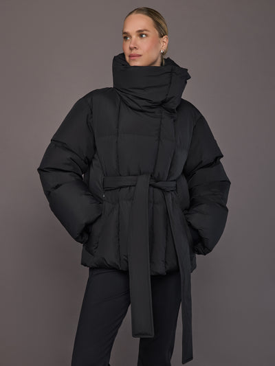 Black quilted down jacket on model, front view with tall collar.