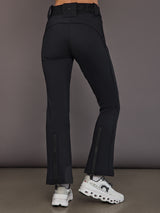 Black softshell ski pant on model, back view with hem zippers.