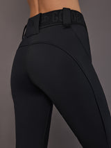 Black softshell ski pant on model, close side view of waist and seams.