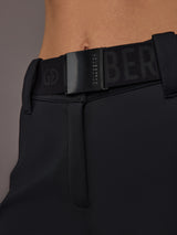 Black softshell ski pant on model, close front view of belt detail.