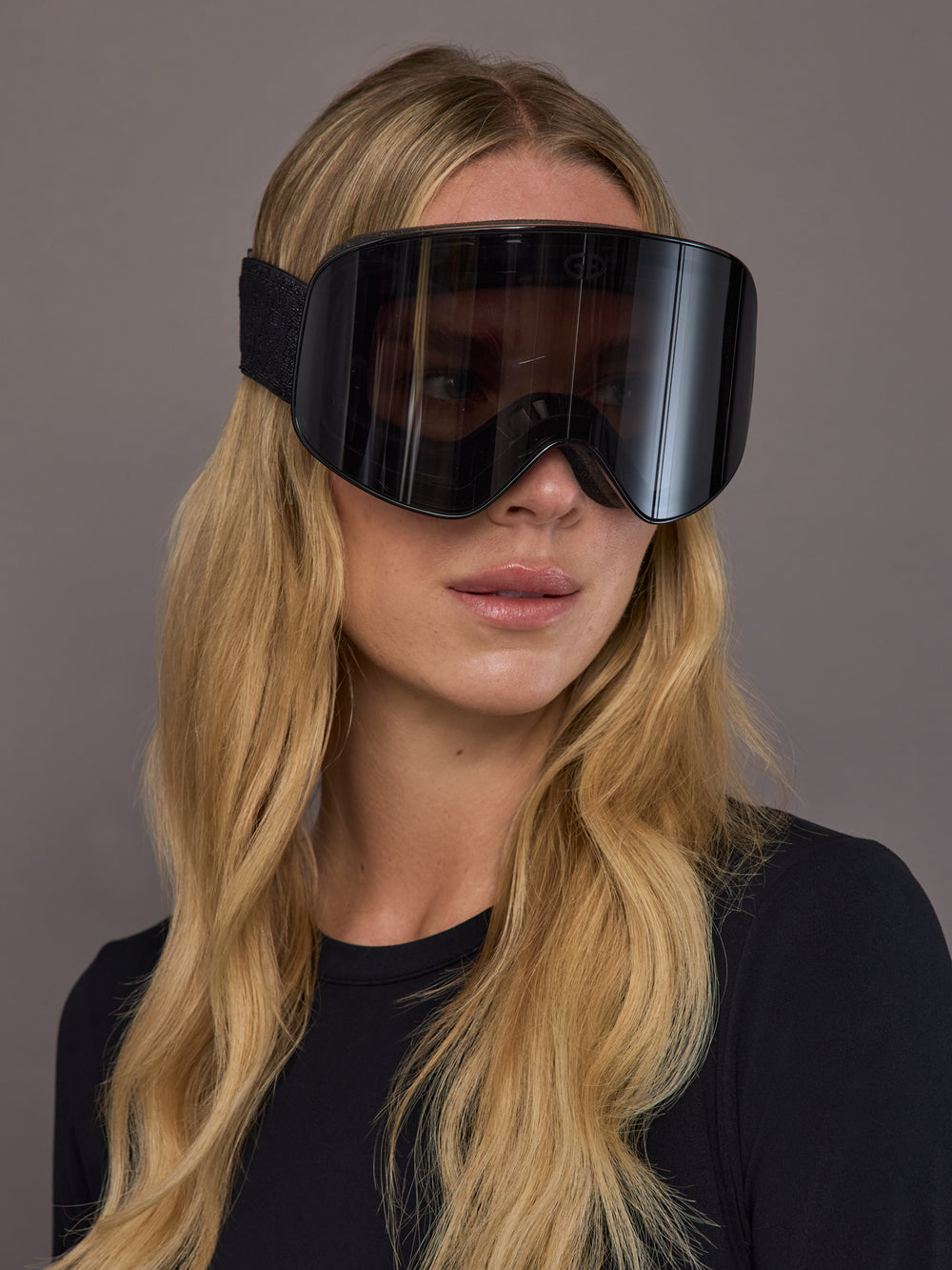 Black frameless ski goggle on model, three quarter front view.