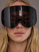 Black frameless ski goggle on model, close front view of lens.