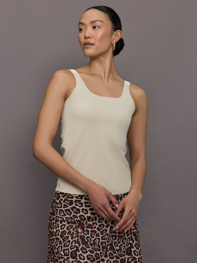 Model wears a neutral colored tank top. 