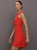 Model wears a cross front cinched waist red mini dress.