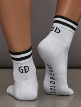 Model wears white athletic sock with contrast stripe patterning.
