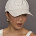 Model wears an off white baseball cap with Goldbergh logo on front.