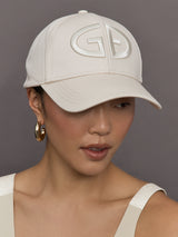 Model wears an off white baseball cap with Goldbergh logo on front.