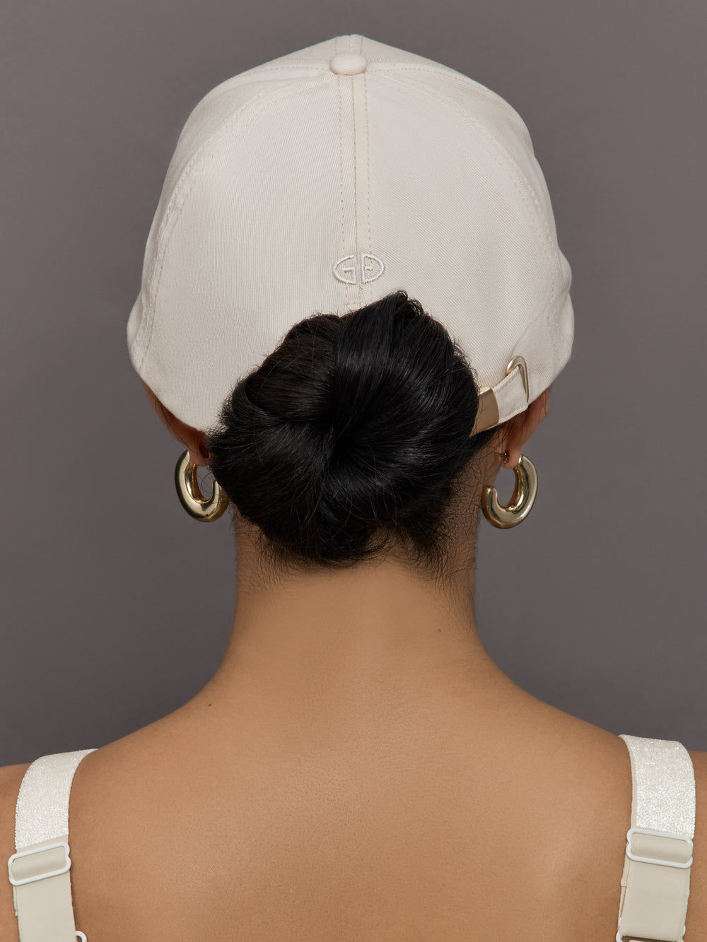 Model wears an off white baseball cap with Goldbergh logo on front.