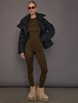 Full-body view of model in leopard leggings and matching top with black jacket.