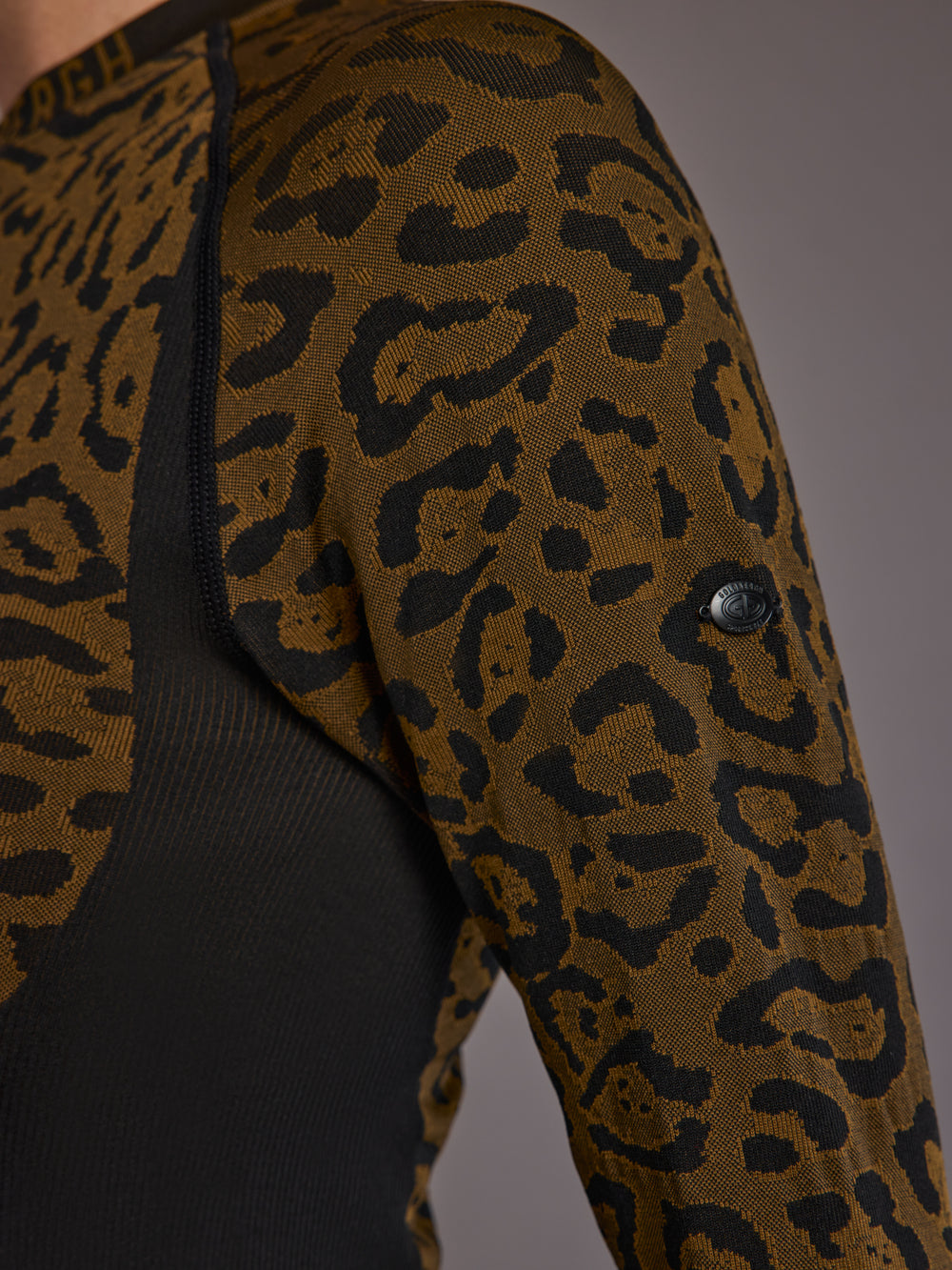 Close-up of leopard knit pattern and sleeve logo detail.