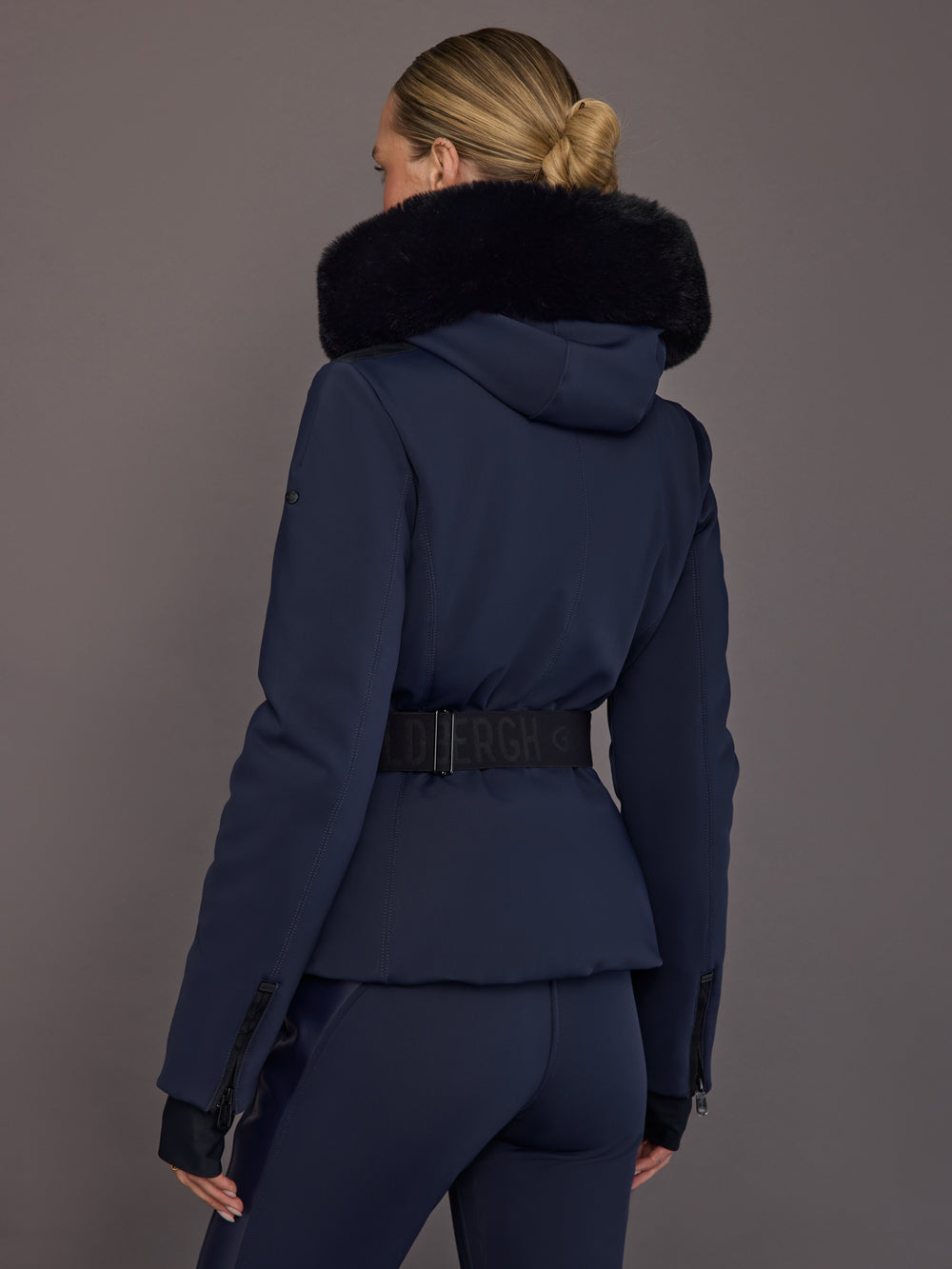 Back view of navy ski jacket with faux-fur trim hood.