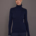 Model wearing ribbed navy turtleneck sweater, front view.